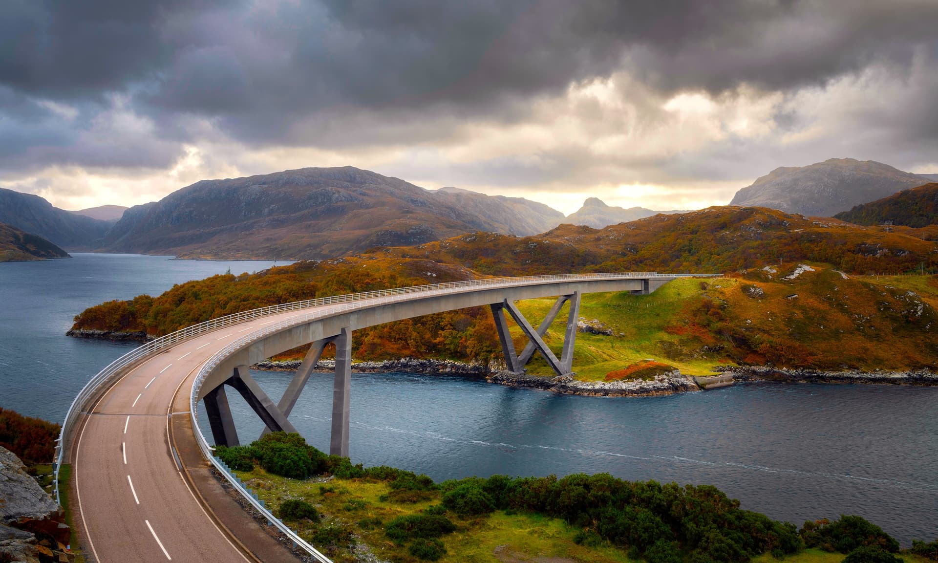 Kylesku road bridge on the Scottish NC500 over dark water with autumn hills.