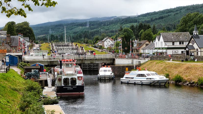 Boats in canal locks at Fort Augustus with village buildings and forested hills